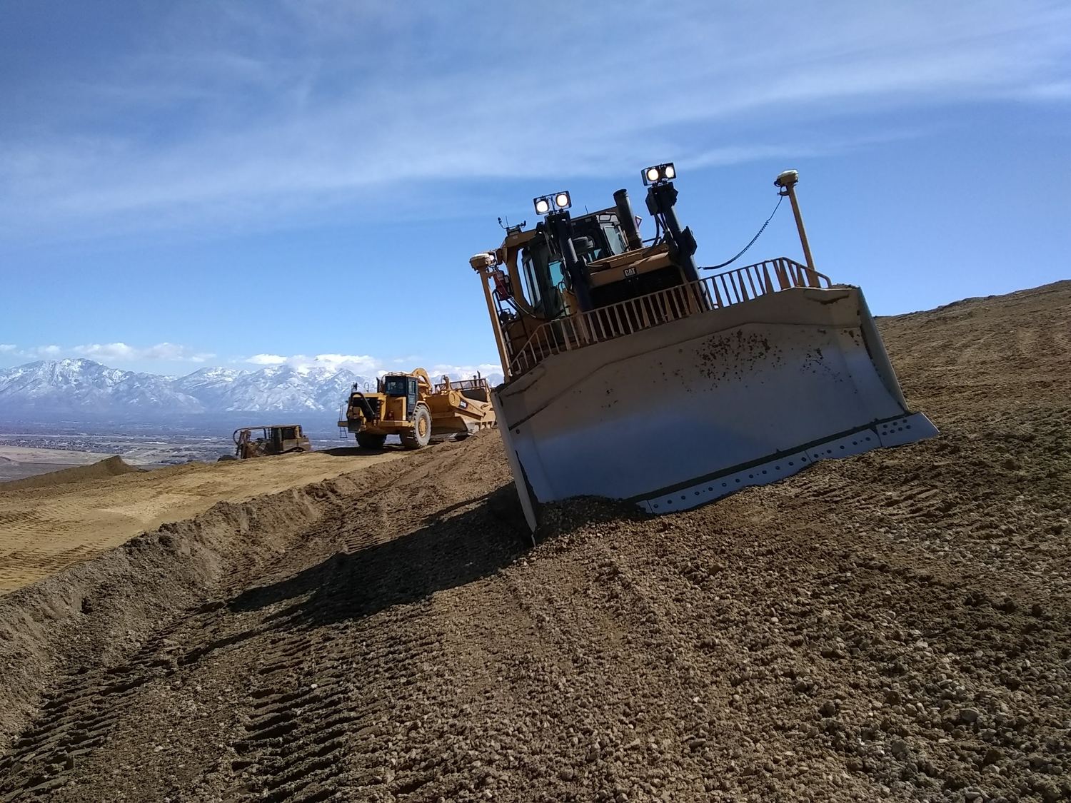Dozer holding grade above the Salt Lake valley and mountain range.