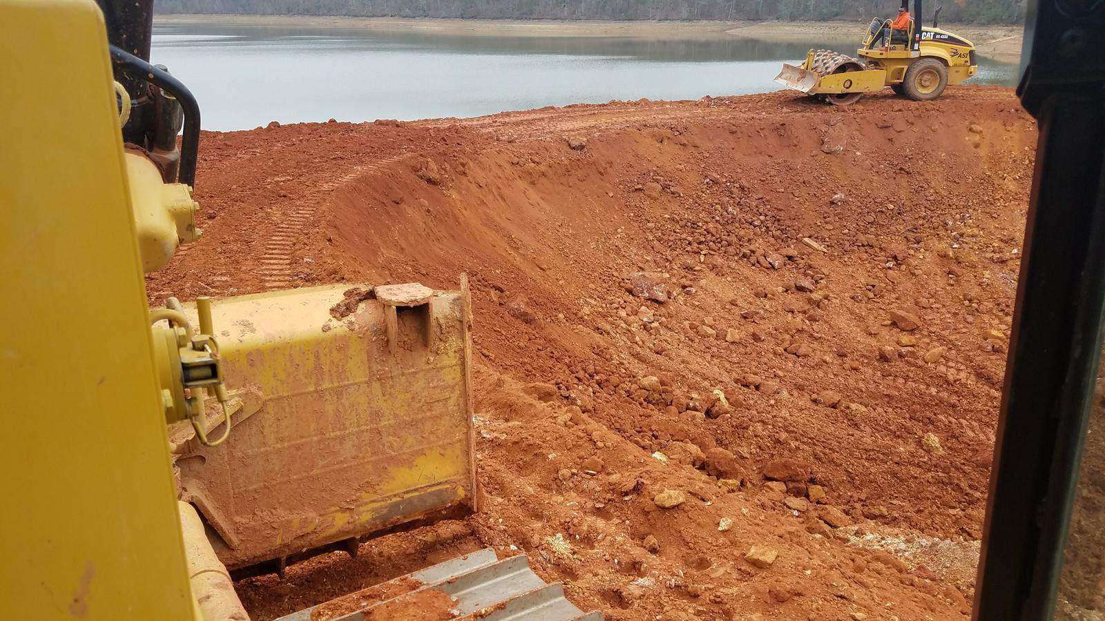 Volvo excavator loading an articulated haul truck on a mass excavation.