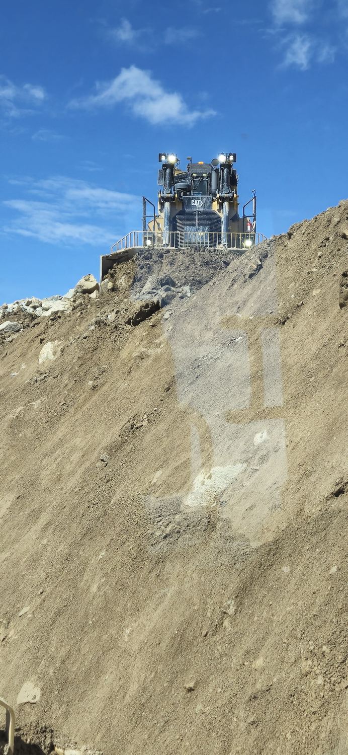 Dozer cresting the top of a large stockpile.
