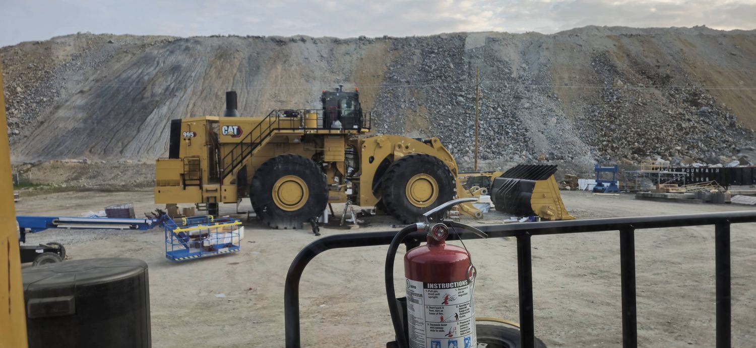 CAT 995 wheel loader parked for service at a rock face.