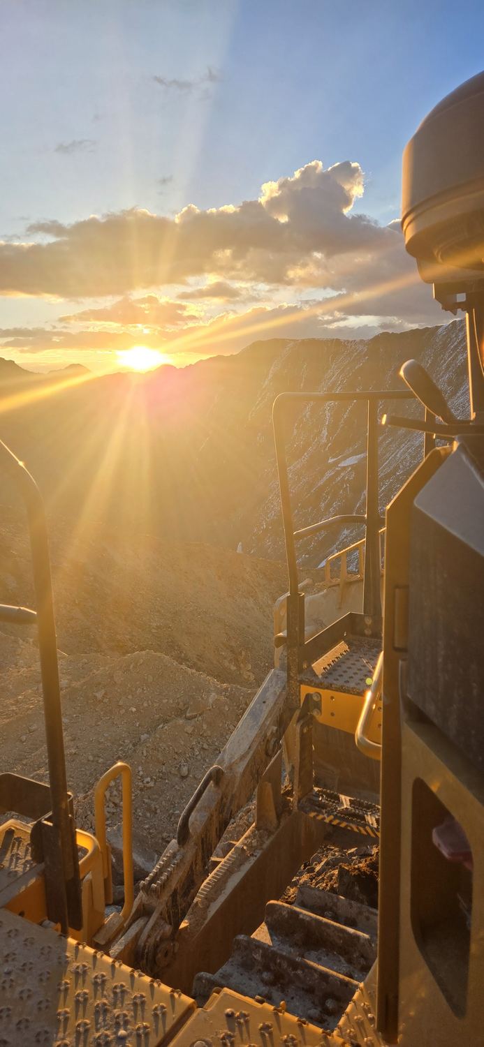 Sunrise light over an open pit mine from inside the cab.