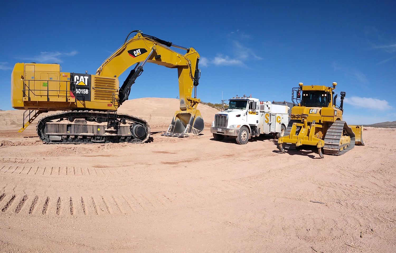 CAT 6015B excavator, service truck, and dozer staged together.