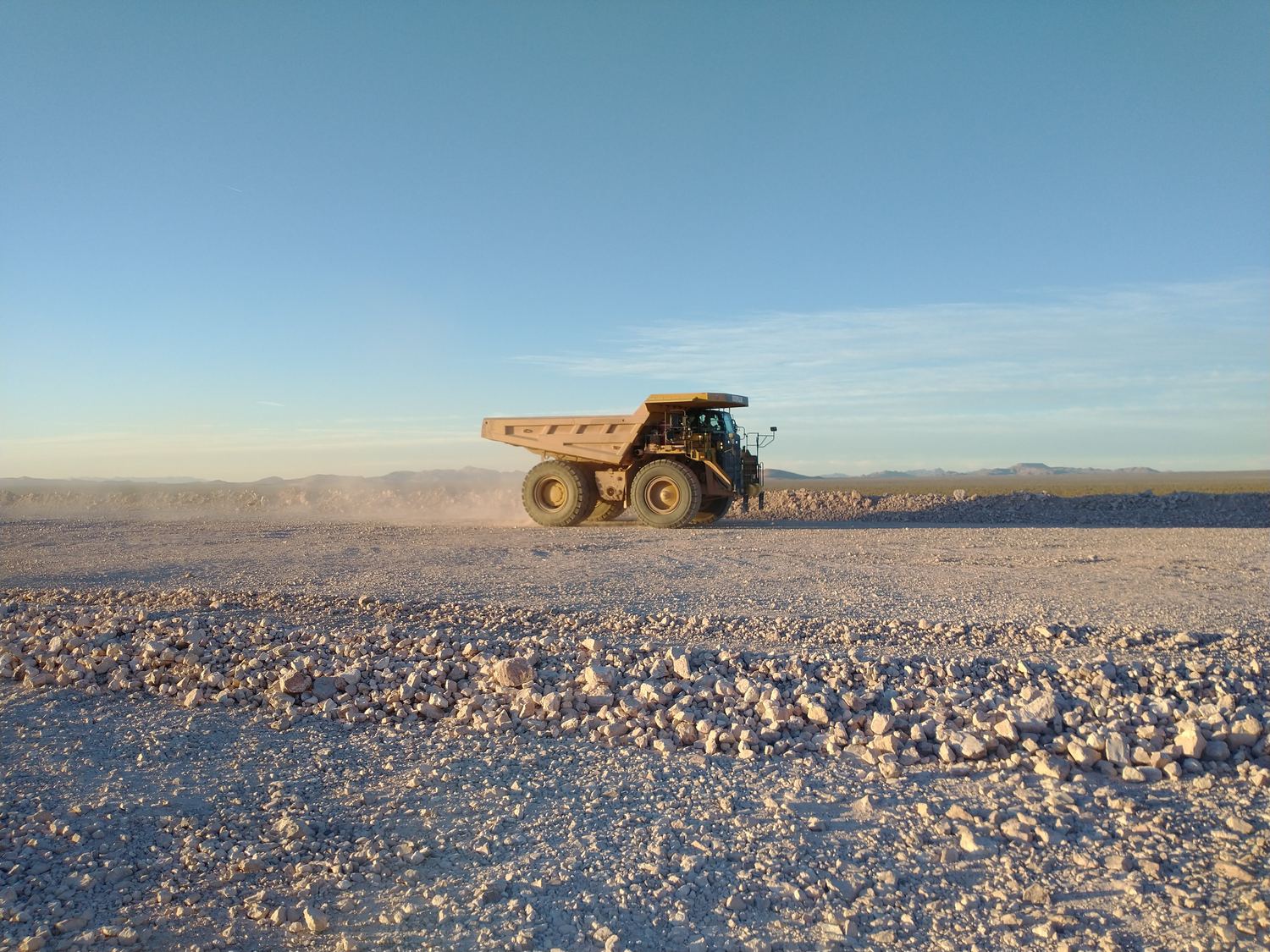 Motor grader blade close, sunset over the range.