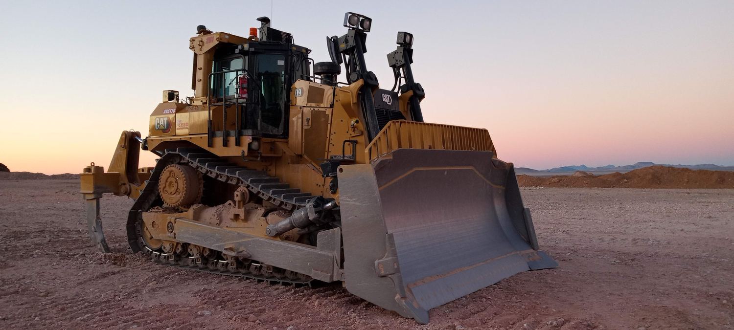 Loader, haul truck, and excavator staged together at day's end.